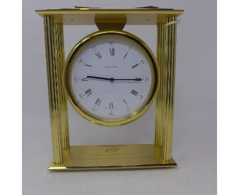 A Tiffany &amp; Co, brass mounted mantle clock having four ribbed columns, circular white dial with black Roman and Arabic nu