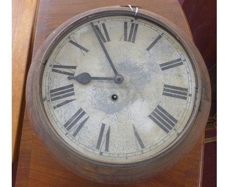 An early 20th century circular wall clock with a white-painted circular metal dial with black Roman numerals, oak frame and w