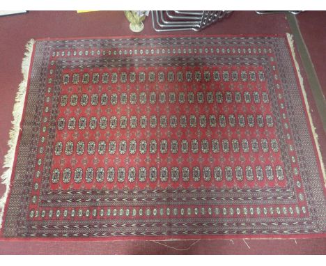 A 20th century Bokhara carpet with repeating gull motifs, on a red ground, contained by geometric border, 263 x 194cm 