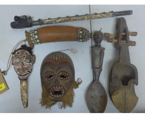 A small collecton of tribal art to include a mask, blow pipe, spoon, instrument, mask on bone stick and a gourd 