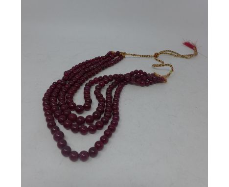 A necklace composed of 4 graduated rows of natural ruby beads of polished, spherical form, L: 65cm, Gross: 240g, largest bead