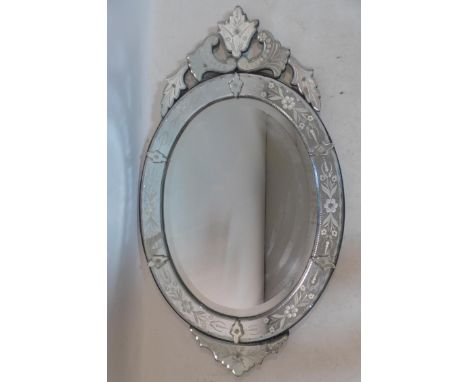 A Venetian style glass mirror, with etched floral design and floral finial, having oval bevelled glass plate, 111 x 63cm 