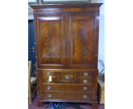 An inlaid mahogany linen press, with two cupboard doors above an arrangement of seven drawers, on bracket feet, H.205 W.130 D
