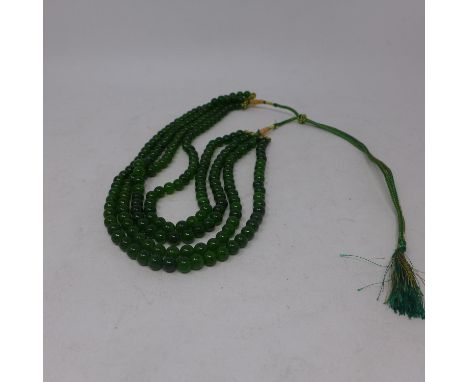 A necklace composed of 4 rows of green jade beads of polished, spherical form, L: 70cm, Gross: 175g, bead dia: 7mm 