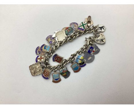 A Vintage Hallmarked Silver Charm Bracelet, with assorted enamel souvenir charms including Plymouth, Canada, Torquay etc. Sta