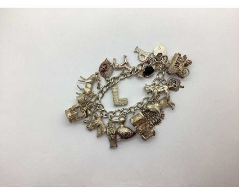 A Vintage Hallmarked Silver Charm Bracelet, with heart padlock feature and assorted charms including enamel, souvenir, novelt