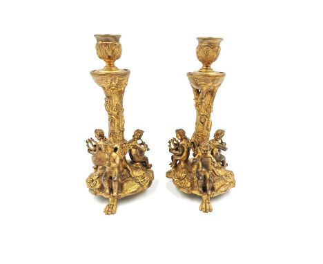 A pair of ormolu candelabras depicting three musical putti/cherubs with lute, flute and song sheet respectively, seated aroun