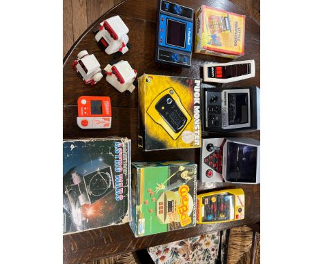 A collection of handheld electronic games including grandstand Astro Wars, Puck Monster, Alex Higgins Cue Ball, Texas Instrum