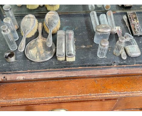 Two leather travelling cases with silver fittings comprising brush set, eight bottles, hip flask, napkin ring, shoe horn and 