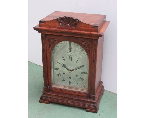 An Edwardian oak mantel clock by Gustav Becker with silvered Roman dial and three train movement, key and pendulum, 42cm high