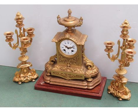 A mid 19th Century French brass and ormolu mantel clock, Roman enamelled dial (hairlined) surmounted by an urn, acanthus ormo