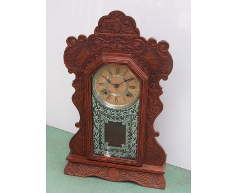 An American Ansonia Clock Co. gingerbread style mantel clock, Roman dial 8 day movement, key and pendulum, 56.5cm high