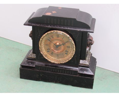 A cast iron mantel clock with lion mask handles, Roman gilded dialwith 8 day movement, key and pendulum, 29cm high