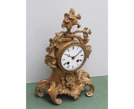 A French ornate gilt metal mantel clock with Roman enamelled dial, 8 day movement, key and pendulum, 25cm high