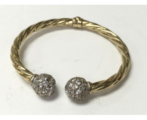 A 9ct gold stone set torc bangle. The approximate weight is 12.7g.