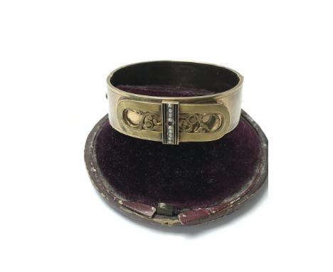 An antique clasp bangle in the formation of a buckle set with seed pearls and in its original box.
