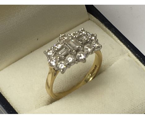 A 18ct gold diamond cluster ring inset with 3 baguette diamonds, surrounded by 12 further diamonds. Ring size N-O