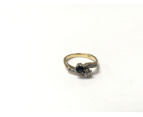 An 18ct diamond and sapphire cross over ring, the approximate ring size is between J and K.