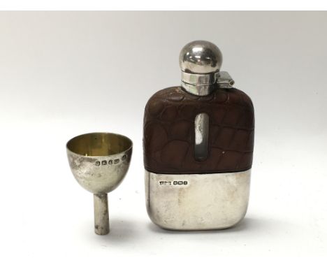 A silver hip flask and a small funnel.