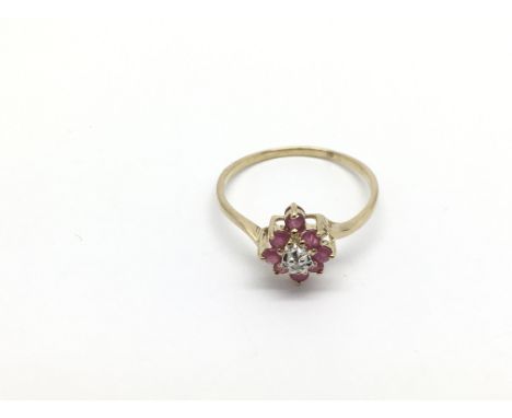 A 9ct gold , ruby and diamond pointed cluster ring with a small round cut diamond . Round cut rubies approx 0.28ct, approx 1.