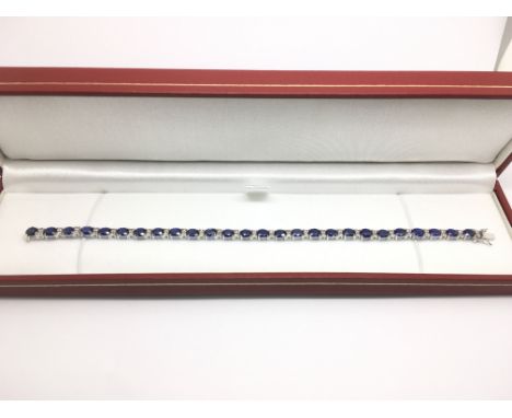 A boxed 18ct white gold, oval sapphire and round cut diamond line bracelet. Sapphires approx 10.73ct, diamonds approx 0.55ct,