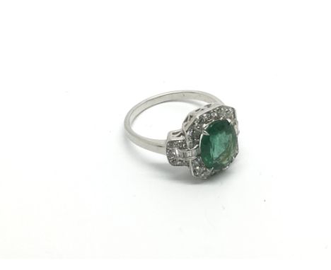 An Art Deco style 18ct white gold oval emerald and diamond cluster ring. Emerald approx 2.19ct, diamonds approx 0.72ct (round