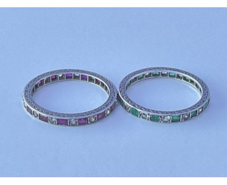 Two eternity rings set with alternating ruby, the other emerald unmarked white metal. Approx 2g. Ring size approx M/N.