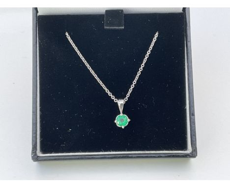 A platinum and emerald pendant on an 18ct white gold chain.