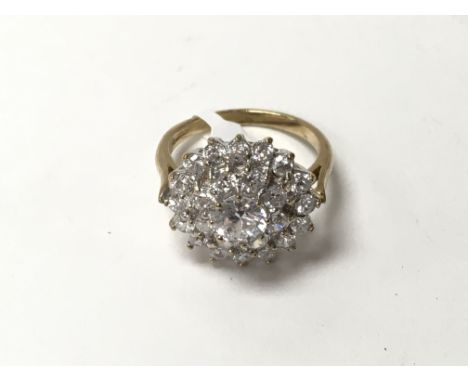 A three tier cluster ring in 9ct gold. The approximate ring size is Q.