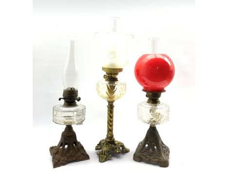 Victorian table oil lamp with glass reservoir on Art Nouveau pierced iron foot H36cm, another on gilded iron foot H34cm and o