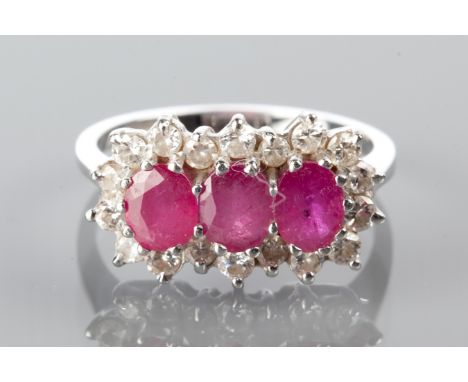 RUBY AND DIAMOND CLUSTER RING
with three oval cut rubies surrounded by brilliant cut diamonds, marked 750 for eighteen carat 