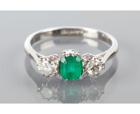 EMERALD AND DIAMOND THREE STONE RING
with a central emerald cut emerald flanked by two brilliant cut diamonds, in palladium, 