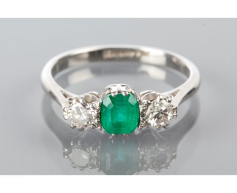 EMERALD AND DIAMOND THREE STONE RING
with a central emerald cut emerald flanked by two brilliant cut diamonds, in palladium, 