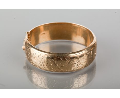 NINE CARAT GOLD BANGLE
engraved with scrolling foliate decoration, hallmarked for nine carat gold, 25.7g