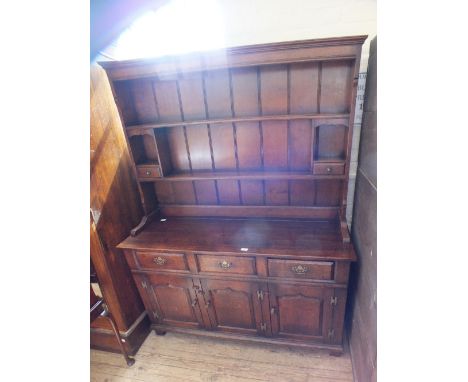 An oak shelf back dresser with three drawers and doors below