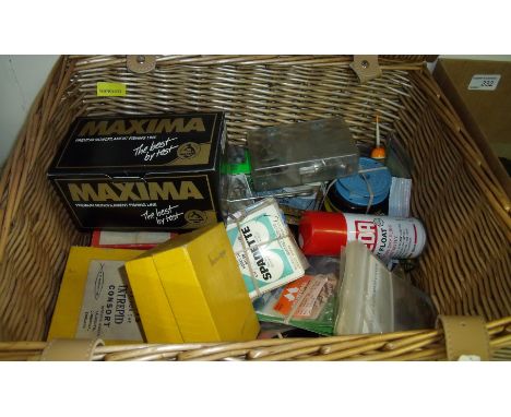 Wicker picnic basket containing large selection of various fishing accessories including flies, floats, balance scales, lures