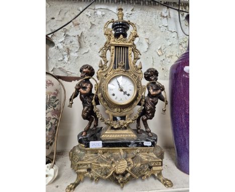 A French style brass and marble mantle clock, decorated with cherubs, the ceramic dial marked 'Imperial, Made in Italy'