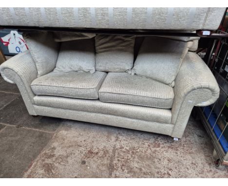 A modern cream two seater sofa with striped upholstery. 