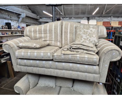 A modern cream two seater sofa with striped upholstery. 