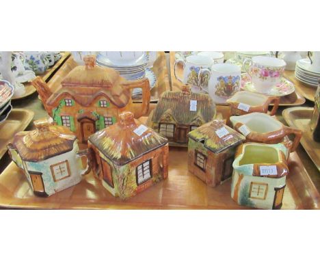 Three trays of pottery cottage design items comprising: teapots, milk jugs, water jug, biscuit barrel, lidded sucrier, conser