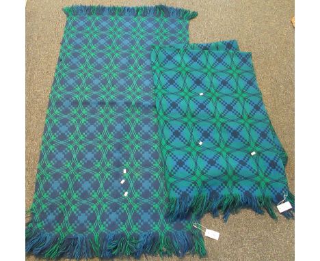 A blue and green geometric design tapestry woollen blanket, with a similar rug and a vintage black ground woollen Welsh tapes