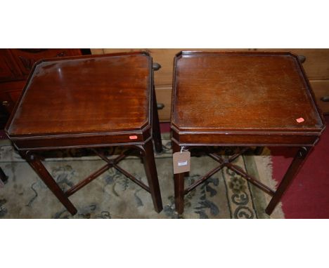 A pair of Georgian style reproduction mahogany lamp tables, having chamfered edges, united by pierced lower X-frame stretcher