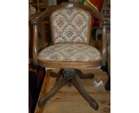 An early 20th century oak, floral tapestry, studded pad back and seat tub swivel desk chair, width 51cm