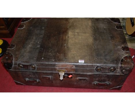 An early 20th century leather close nailed travelling trunk, having end carry handles, w.84cm