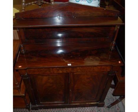 A George IV flame mahogany chiffoniere, having an architectural raised superstructure over single blind frieze drawer to twin