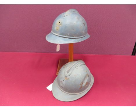 Two WW1 French 'Adrian' Pattern Steel Helmets blue painted crown. Attached front peak and rear brim with side seam. Top crown