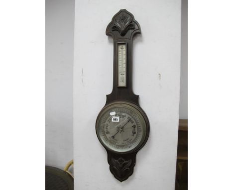 An Early XX Century Oak Cased Wall Barometer, with applied floral motifs, silvered dial and thermometer to neck, 79.5cm high.