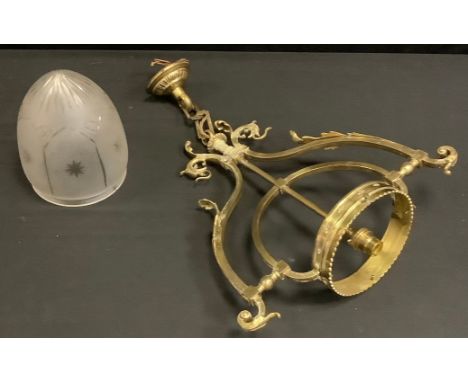 A Victorian brass pendant light fitting, shaped scrolling foliate and dragon mask arms, crowned collar with frosted and cut g