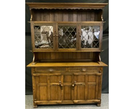 A 20th century Nigel/Rupert Griffiths style oak dresser, outswept cornice above three astragal glazed cupboard doors enclosin