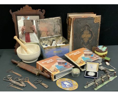 A late 19th century Holy Bible, brass bound;  coloured postcards;  a pestle and mortar;  scissors;  Vauxhall type mirror;   c